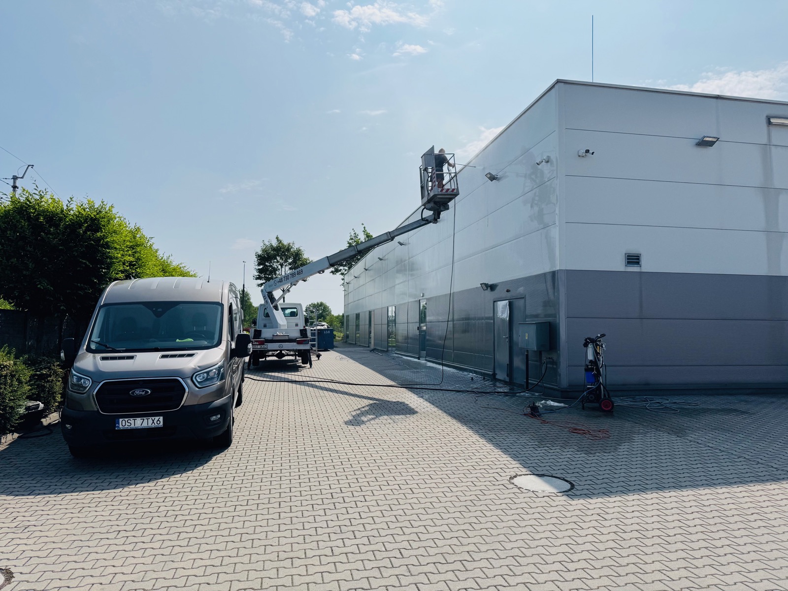 Mycie elewacji budynku komercyjnego z podnośnika